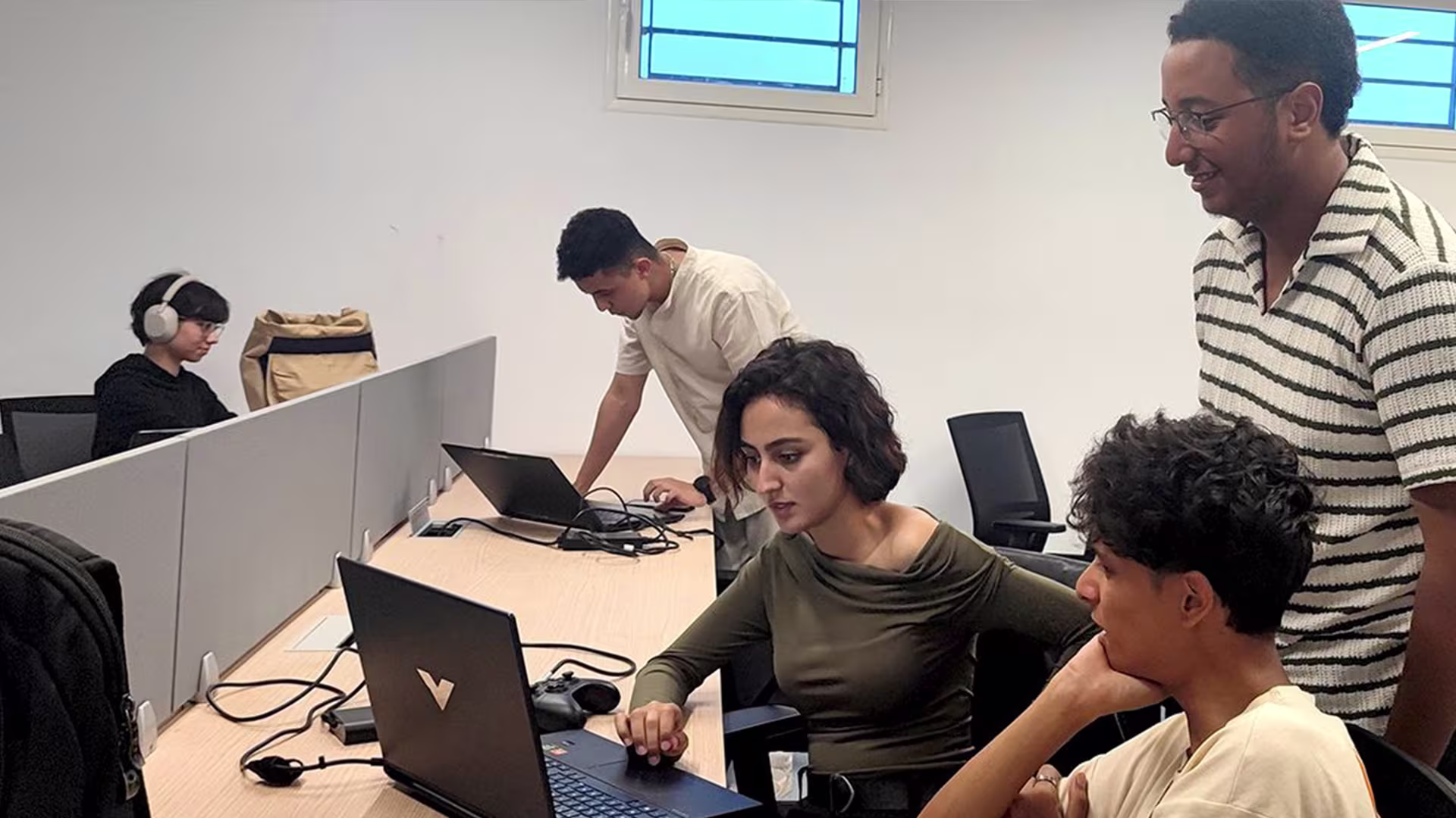 Developers collaborating on laptops during the Morocco 2100 game jam